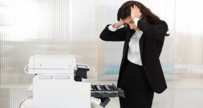 Stressed Woman Staring At A Broken Printer